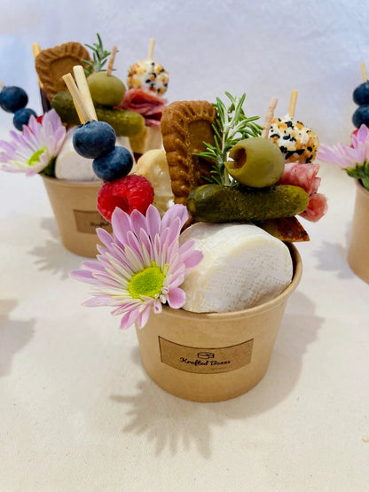 Assorted snacks in a paper cup with flowers on a white background