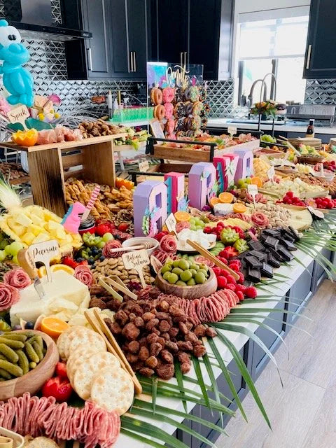 Colorful fruit and dessert display in a kitchen setting with 'PIÑA COLADA' sign.