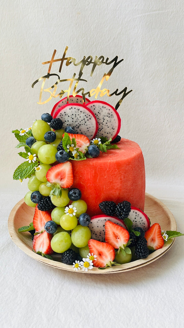 Fruit platter with a 'Happy Birthday' decoration on a white background